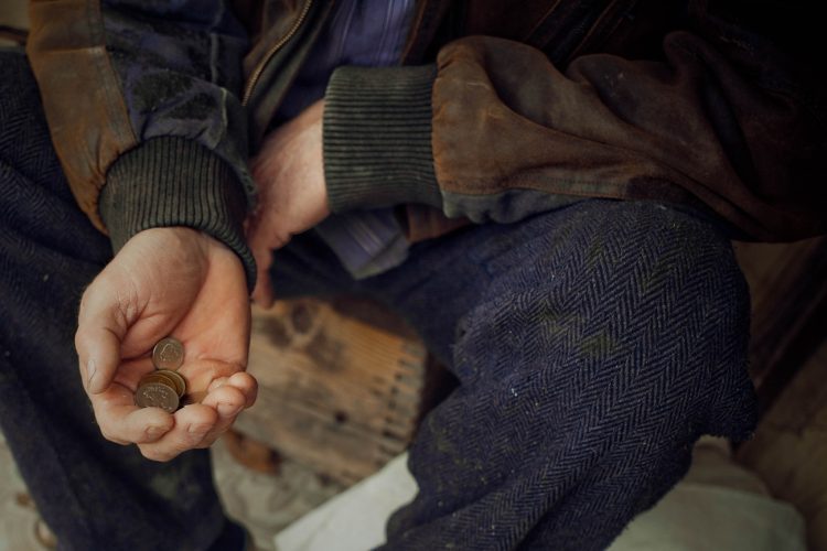 The hand of an elderly man holding Ukrainian money. Poverty, donations, unemployment, charity
